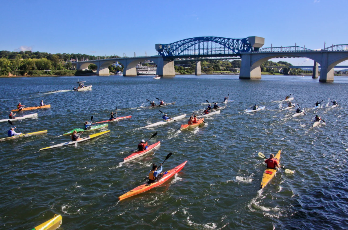 many kayaks on the tennessee river line near a bridge