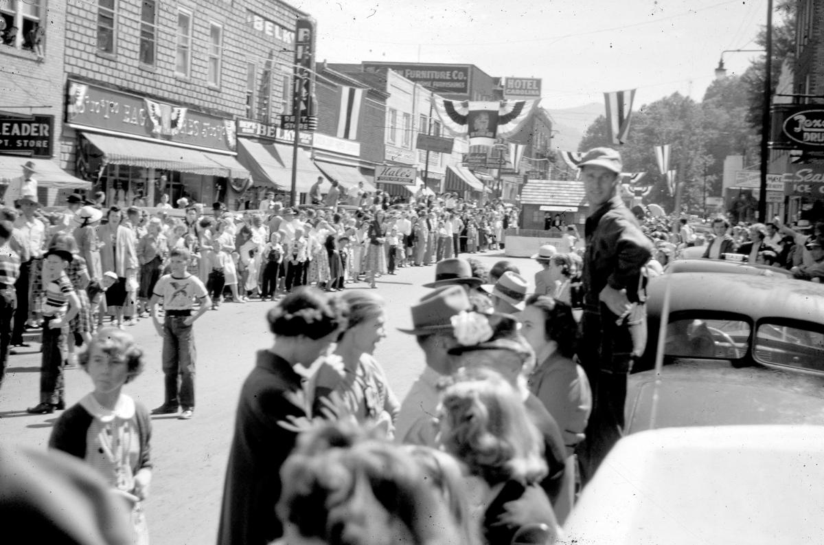 Crowds line Main Street in Sylva, NC, under patriotic bunting for the 1951 Jackson County Centennial parade, past The Leader, Belk and Hale’s