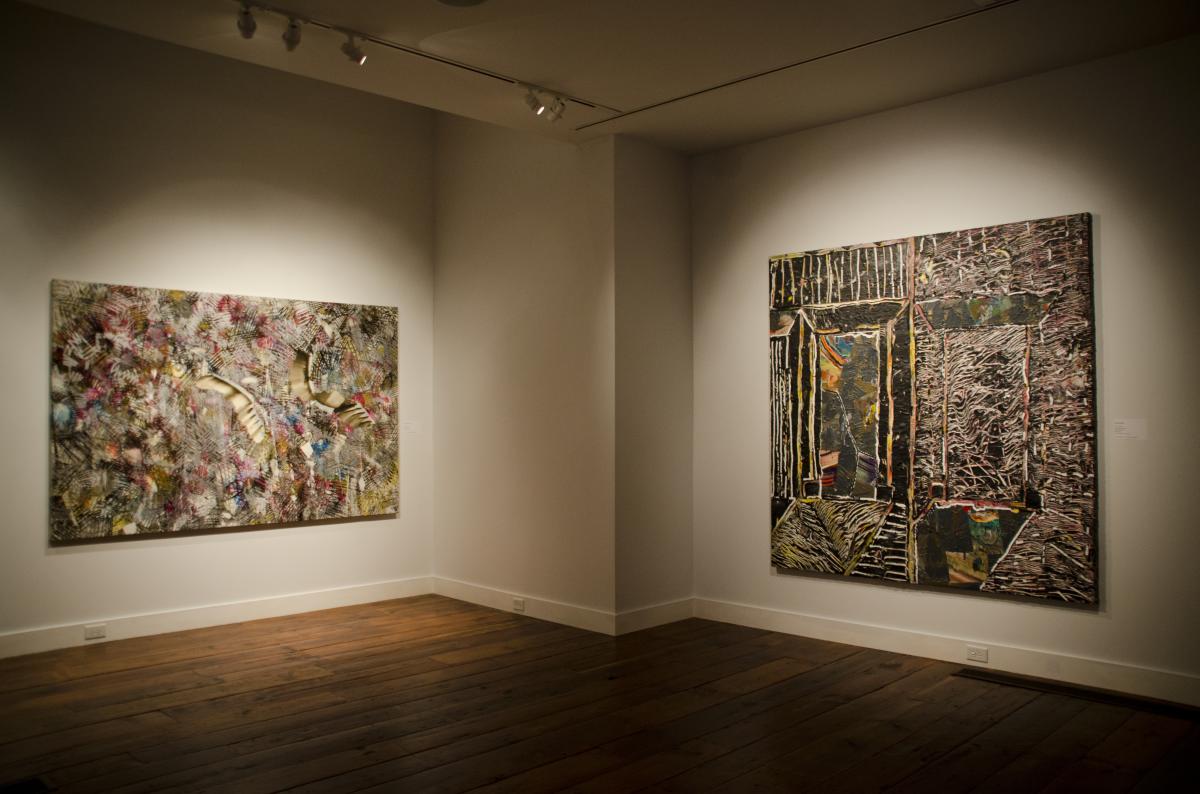 Two large abstract paintings hanging up in an art exhibit.