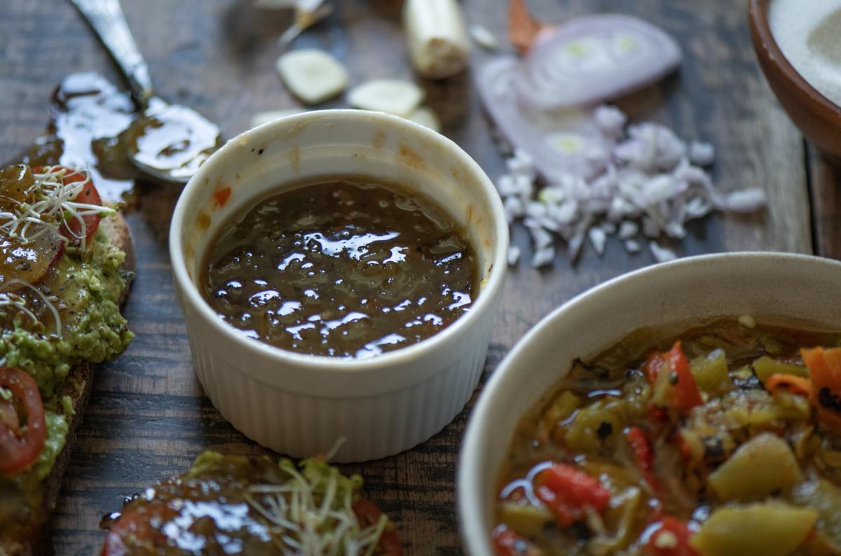 A close-up of a wooden table with three small bowls and a slice of bread with toppings.