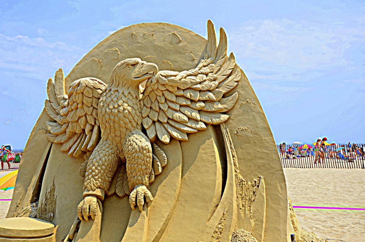 Sand sculpture of an eagle with its wings spread.