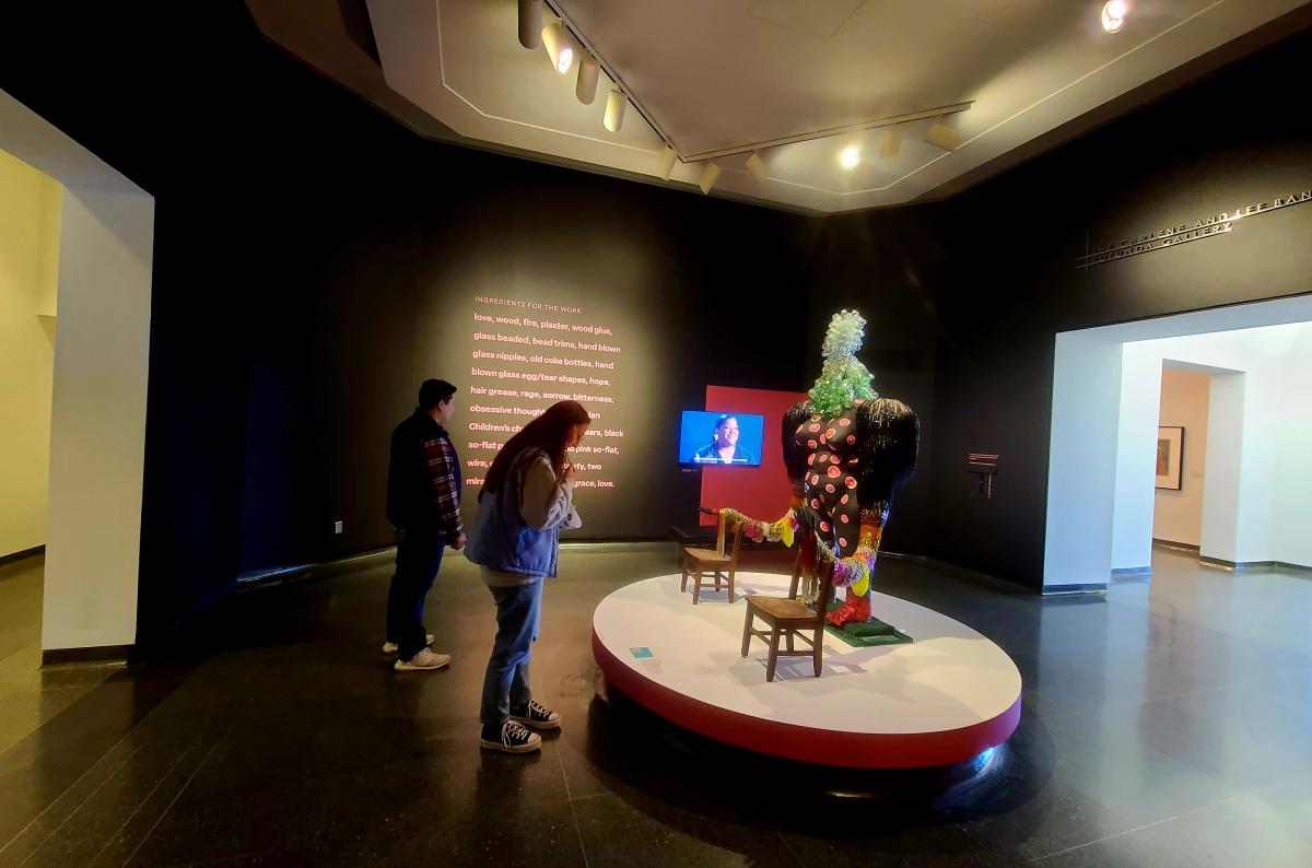 Two poeple look at artwork on display at the Wichita Art Museum