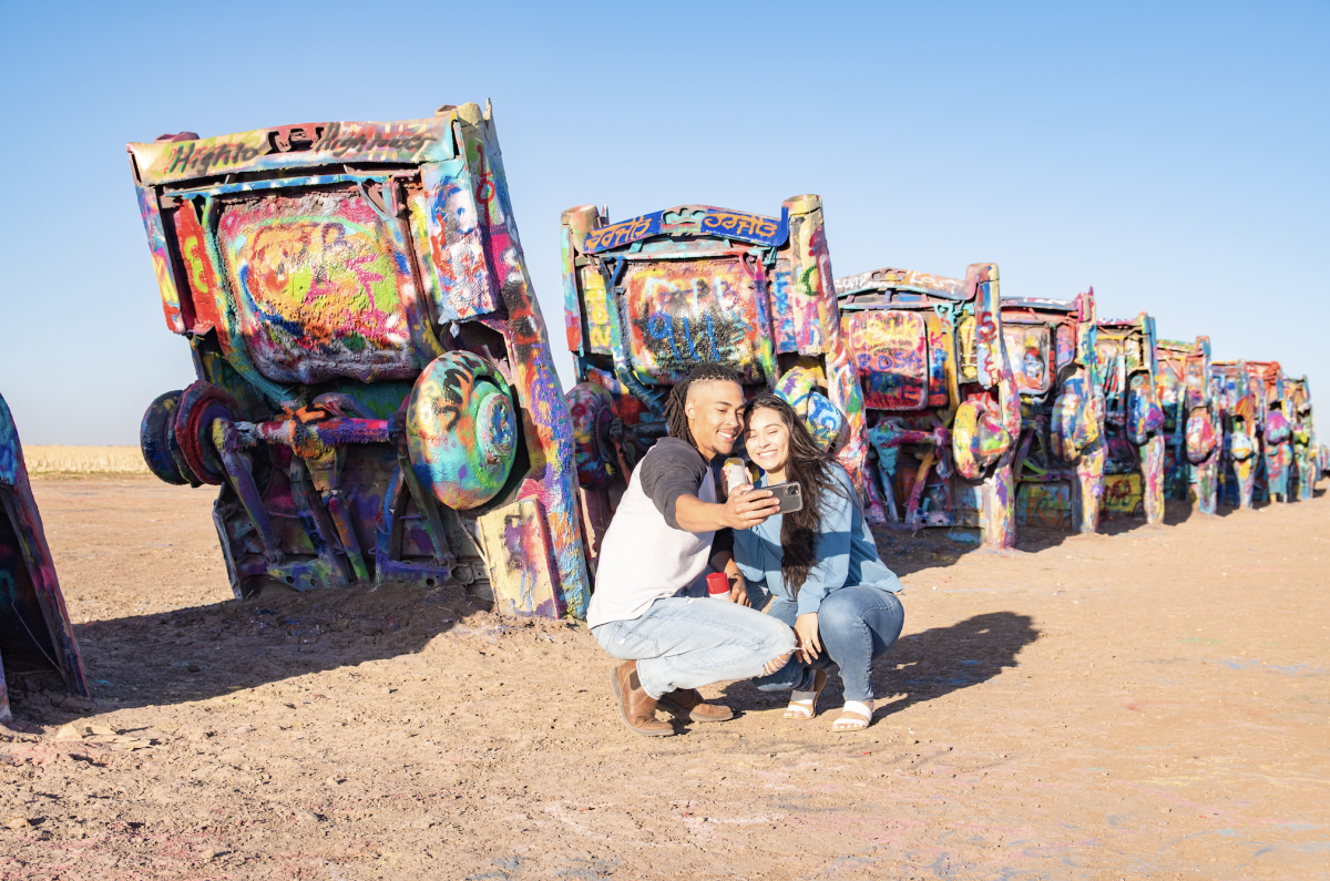 Couple taking a selfie in front of cadillac ranch in Amarillo, texas