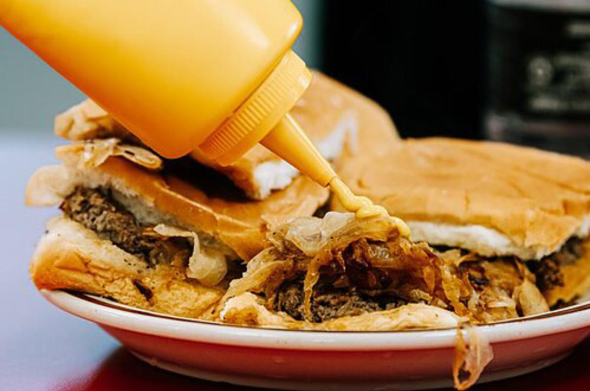 Pouring mustard on a Powers Burger in downtown Fort Wayne