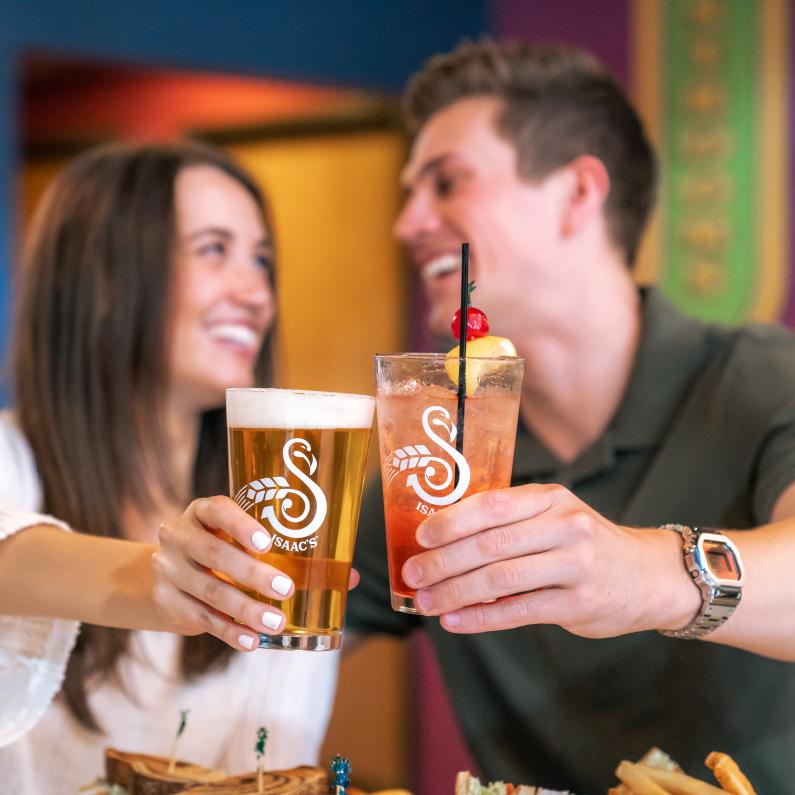 Couple doing cheers with beer at Isaac's Craft Kitchen & Brewery in Lemoyne