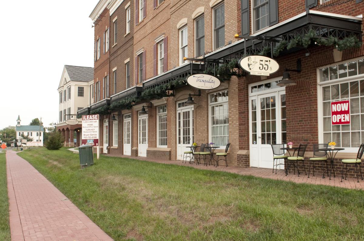 View of the exterior building with shop signs hanging in the town of Haymarket