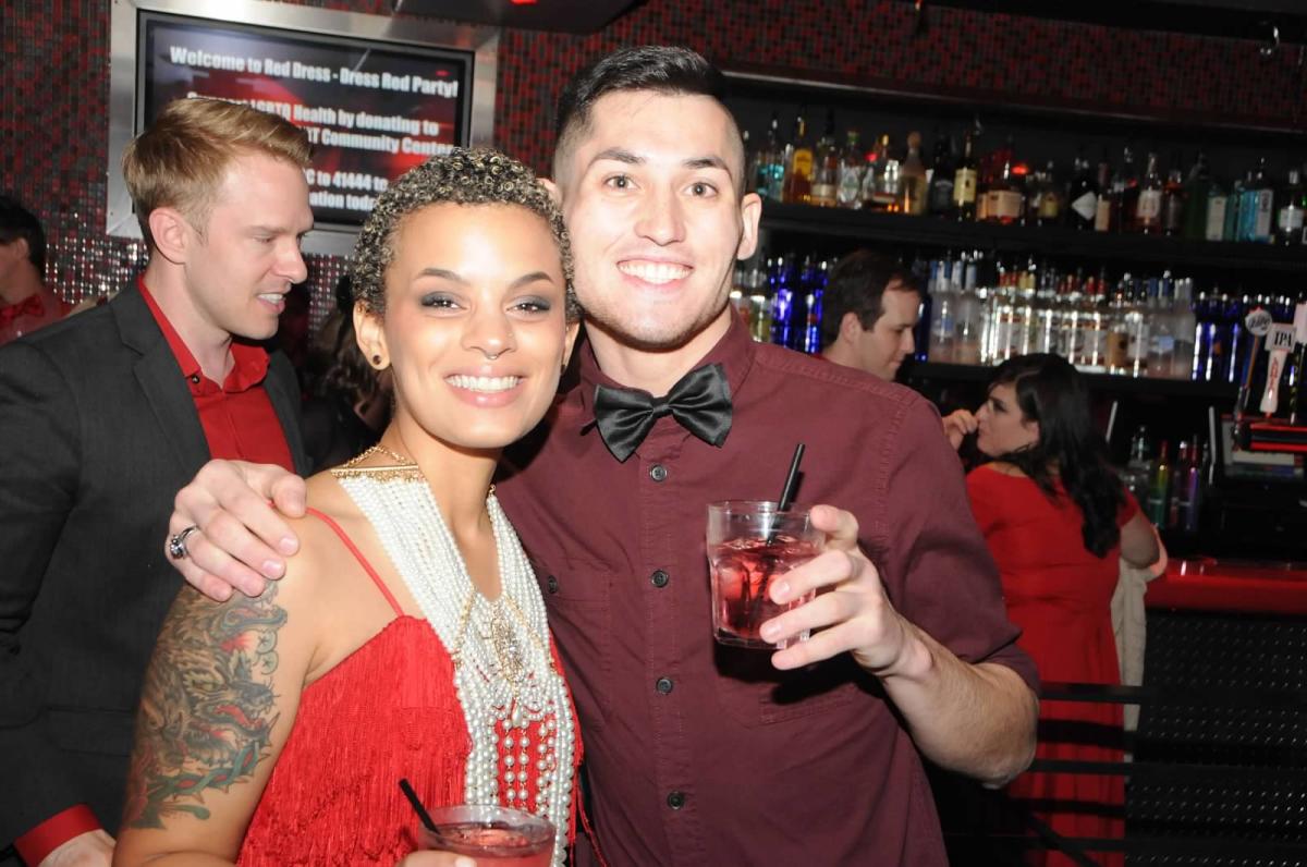 people with their arms around each other having drinks at a bar