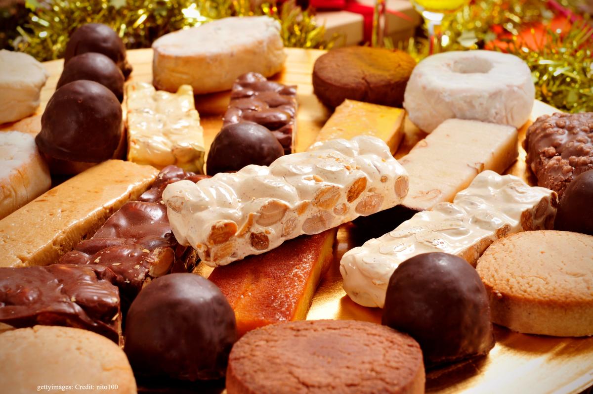 Typical Spanish sweets -- including turron, mantecados and polverones -- piled on a table at Christmas.