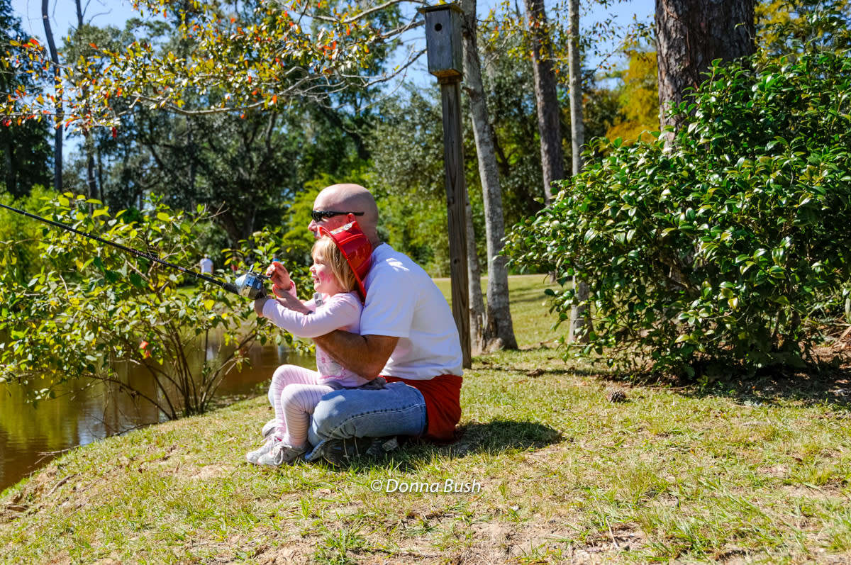 Man teaches little girl to fish at Wild Things at the Southeast Louisiana Wildlife Refuges Headquarters in Lacombe