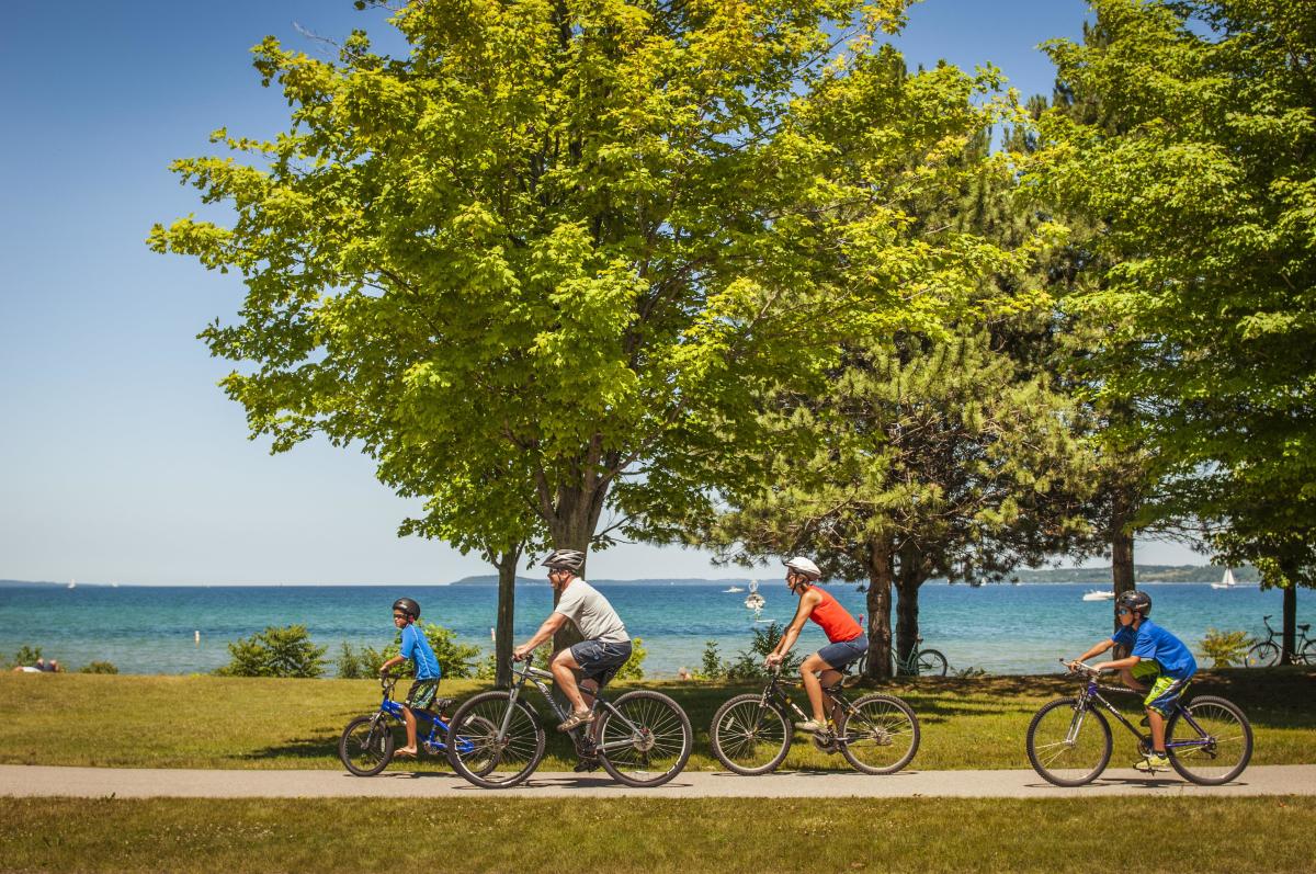 Family biking along bay in summer