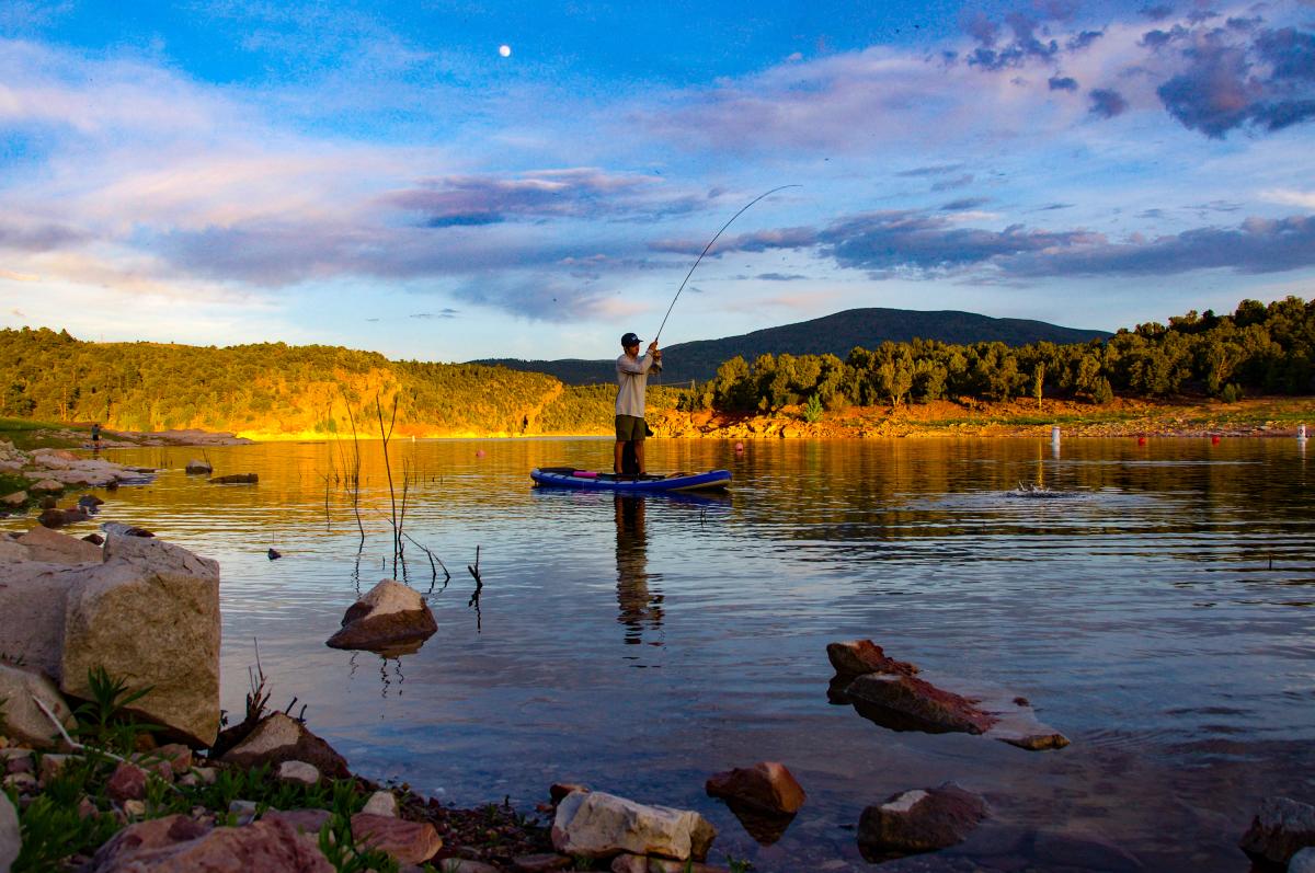 Man fishing while on SUP or stand up paddle board on Flaming Gorge
