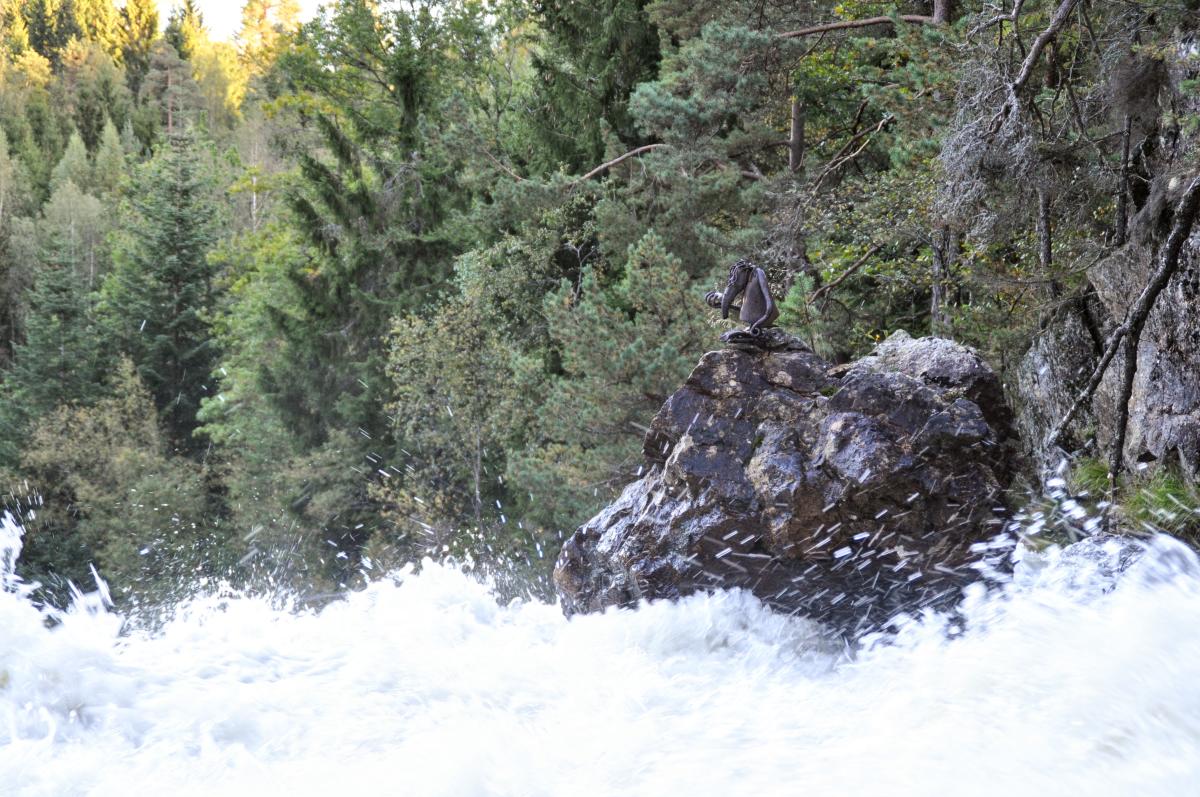 Skulptur på stein i elv