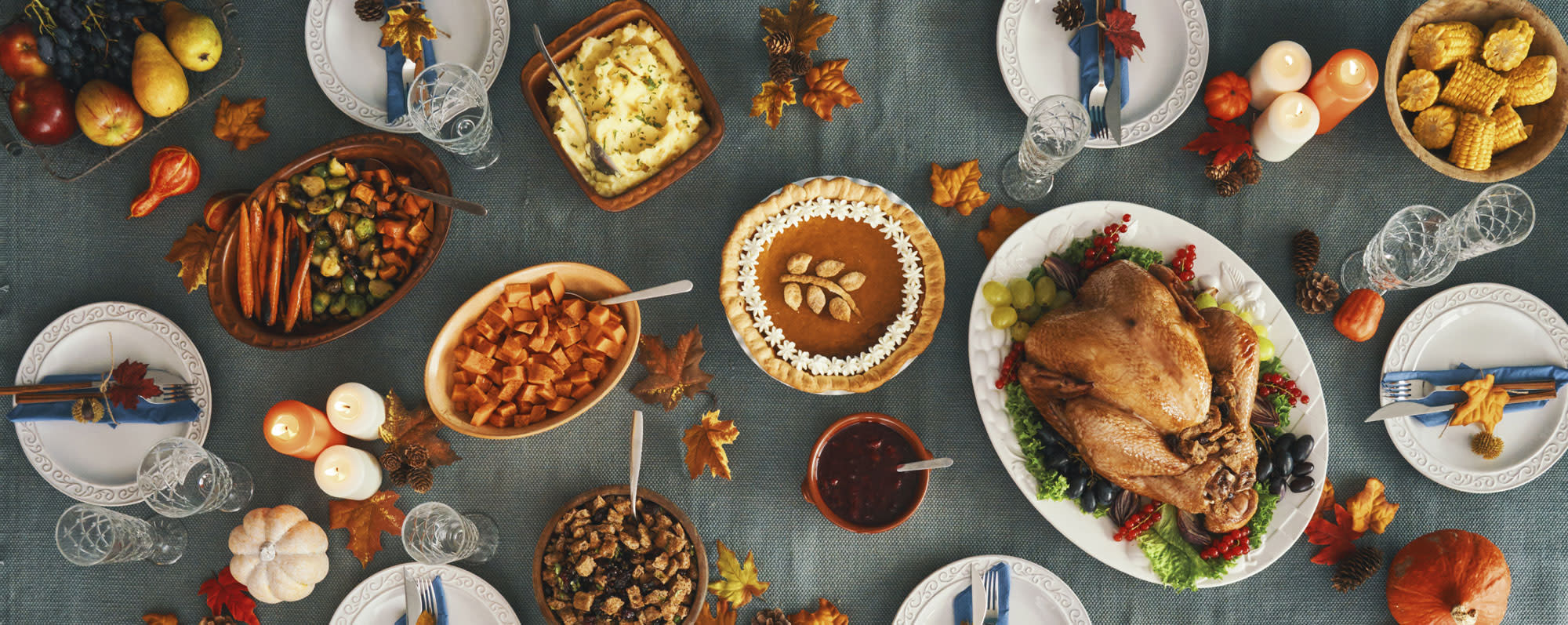 A table filled with Thanksgiving dishes like turkey and vegetables