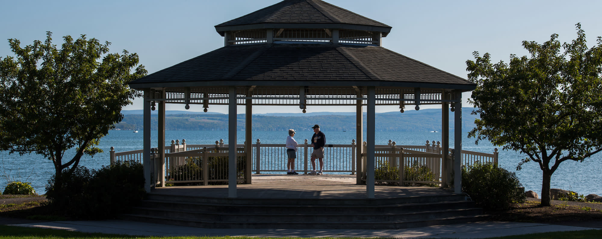 Two people standing in a gazebo overlooking Canandaigua Lake