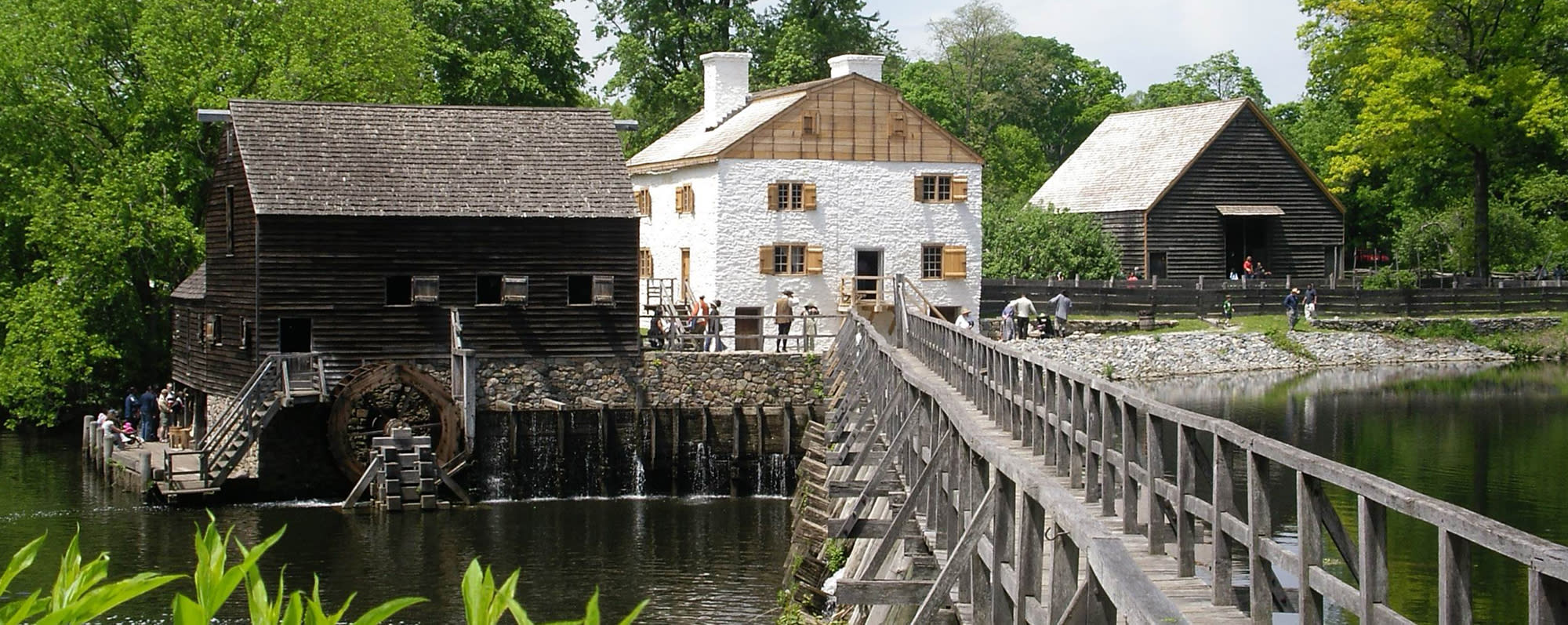 The exterior of Phillipsburg Manor Mill and Bridge from across a bridge