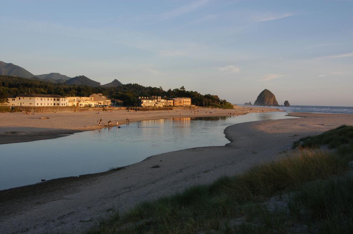 Ecola Creek flows past oceanfront hotels towards Haystack Rock and the Pacific Ocean.