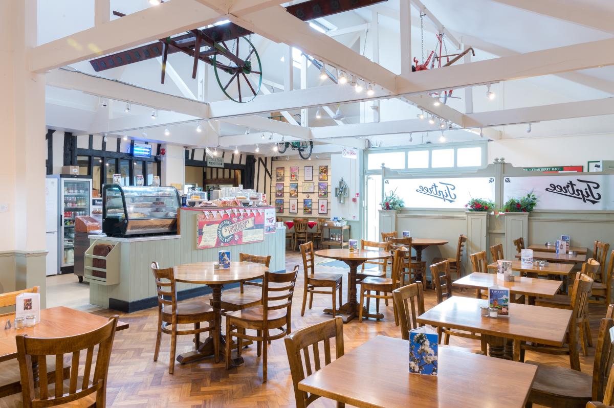Inside Tiptree tea room showing table and chairs and counter with jam