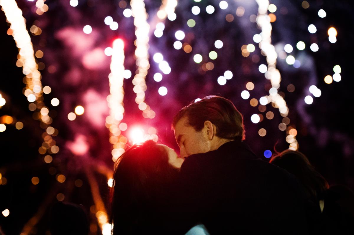 A couple kisses underneath the fireworks at Light Up Eau Claire