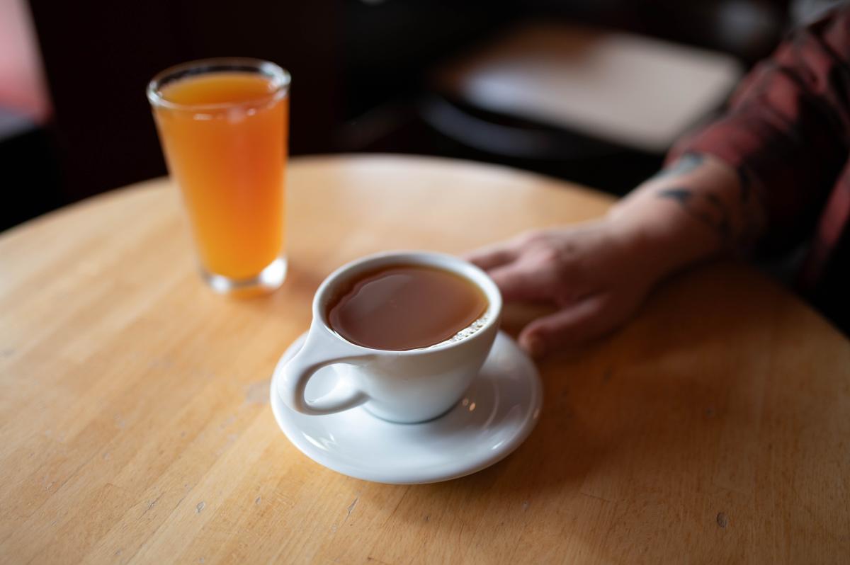 A person holding a cup of hot cider