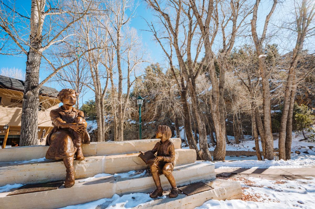 A bronze statue of a woman and another bronze statue of a child