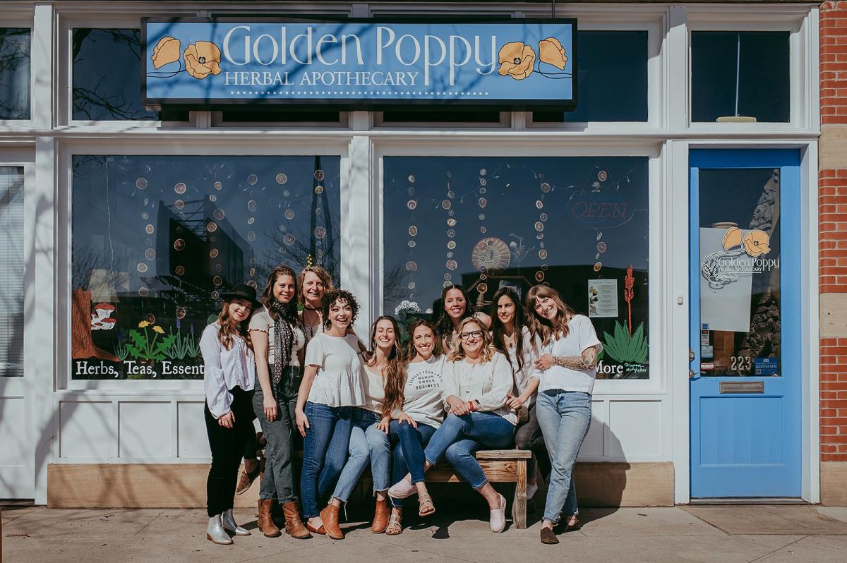 10 women in front of the Golden Poppy store.