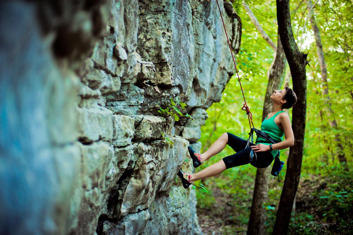 A woman rock climbing on Stone Cuts Trail at Monte Sano Mountain, AL