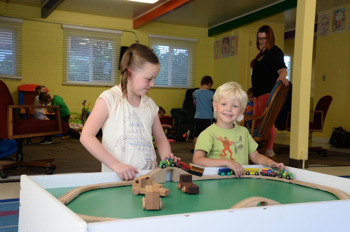 Children play with a wooden trail at the indoor play area at the Utah Shakespeare Festival Childcare facility.