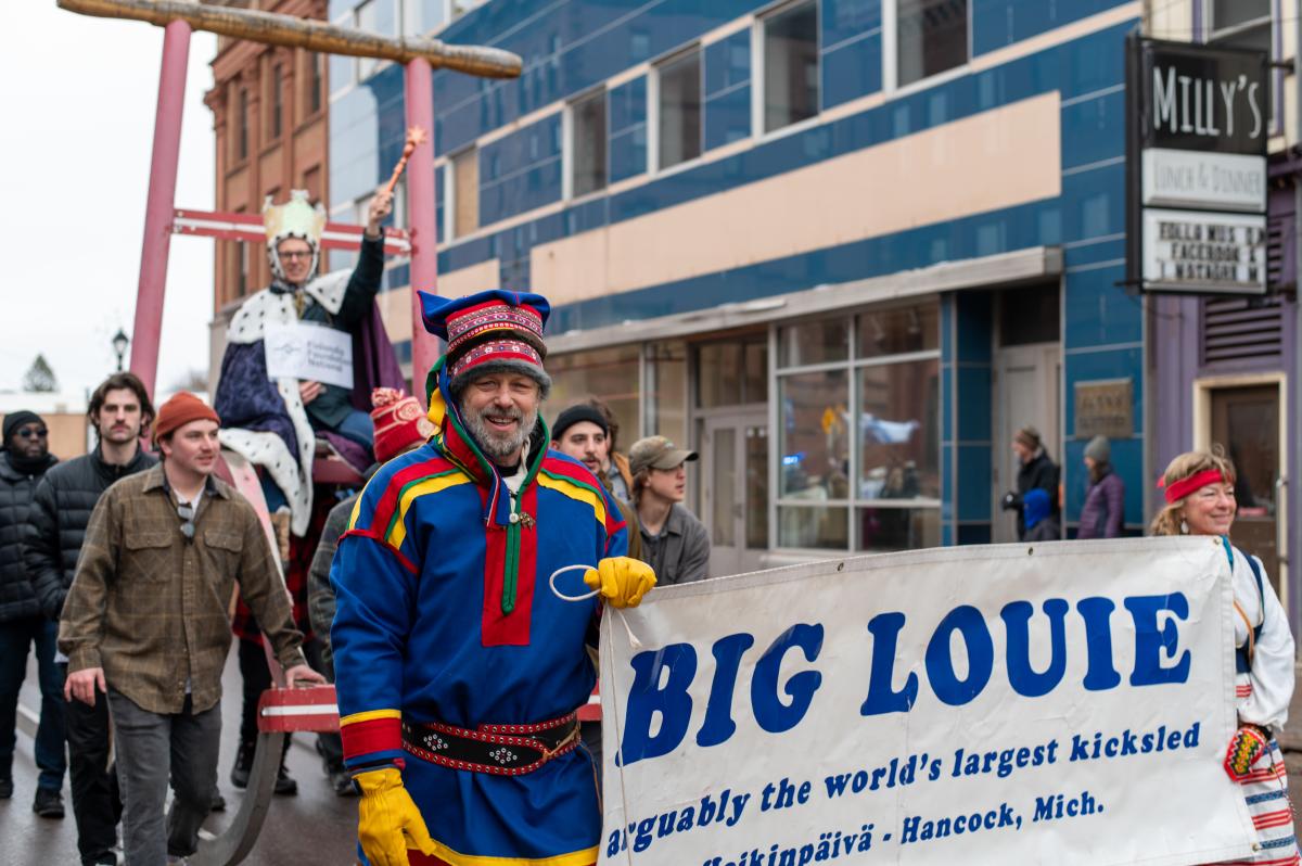 people in finnish american dress walk in a parade