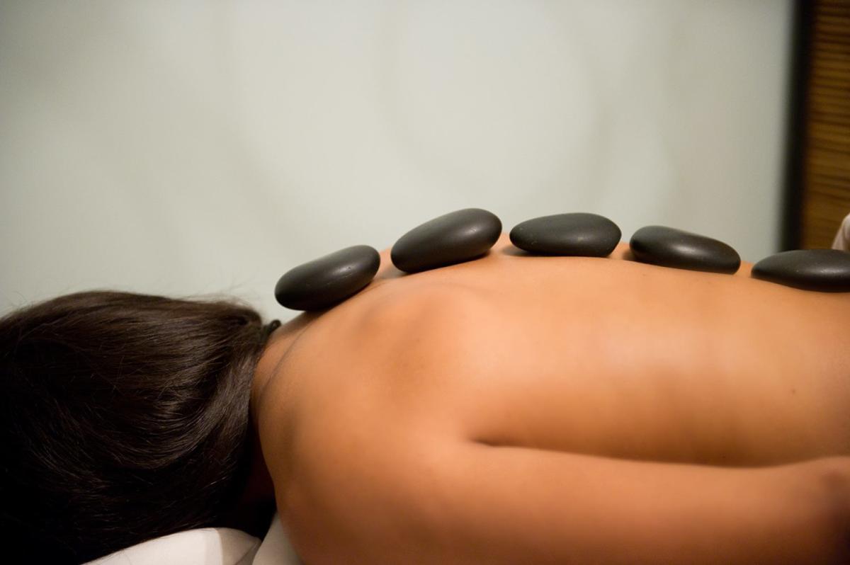 Woman with hot stones along spine at the River Spa in Lafayette