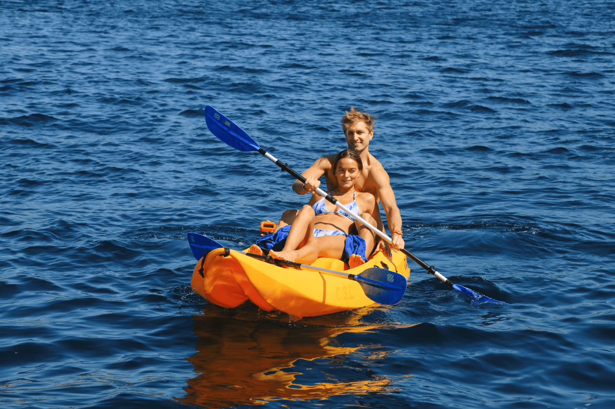 Pareja heterosexual haciendo kayak en el mar