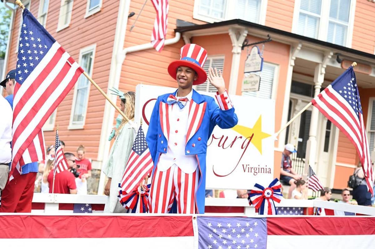 A man dressed as Uncle Sam rides on a float adorned with American flags and red, white and blue bunting during the Leesburg 4th
