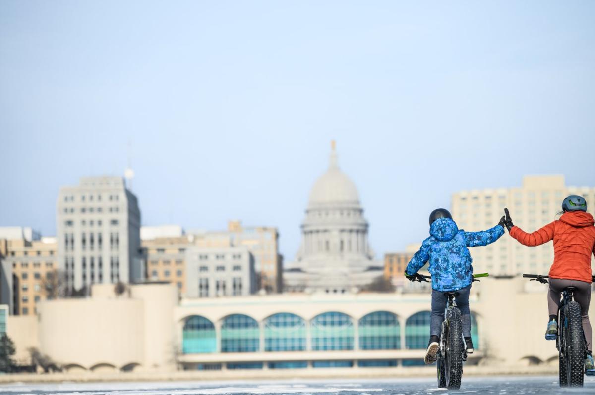 Two people bike on frozen Lake Monona