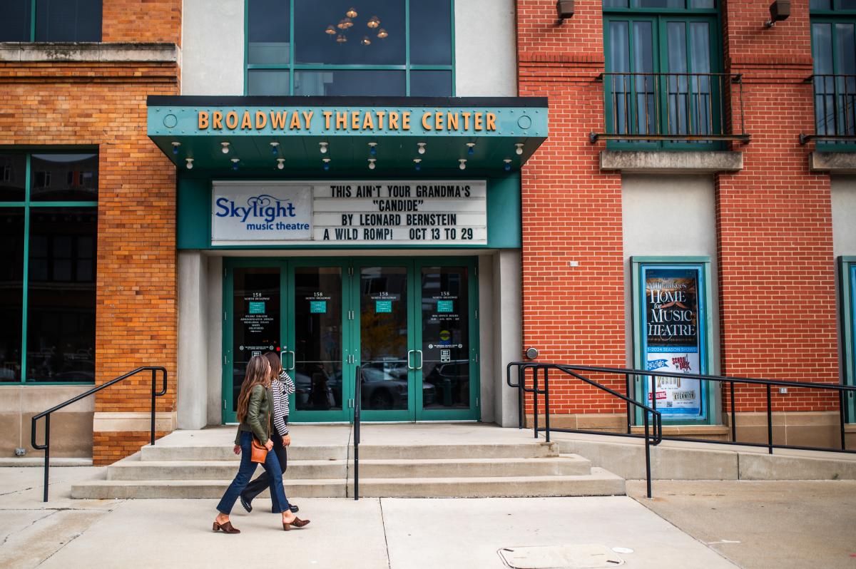 Two people walking in front of Broadway Theatre Center, home of Skylight Music Theatre