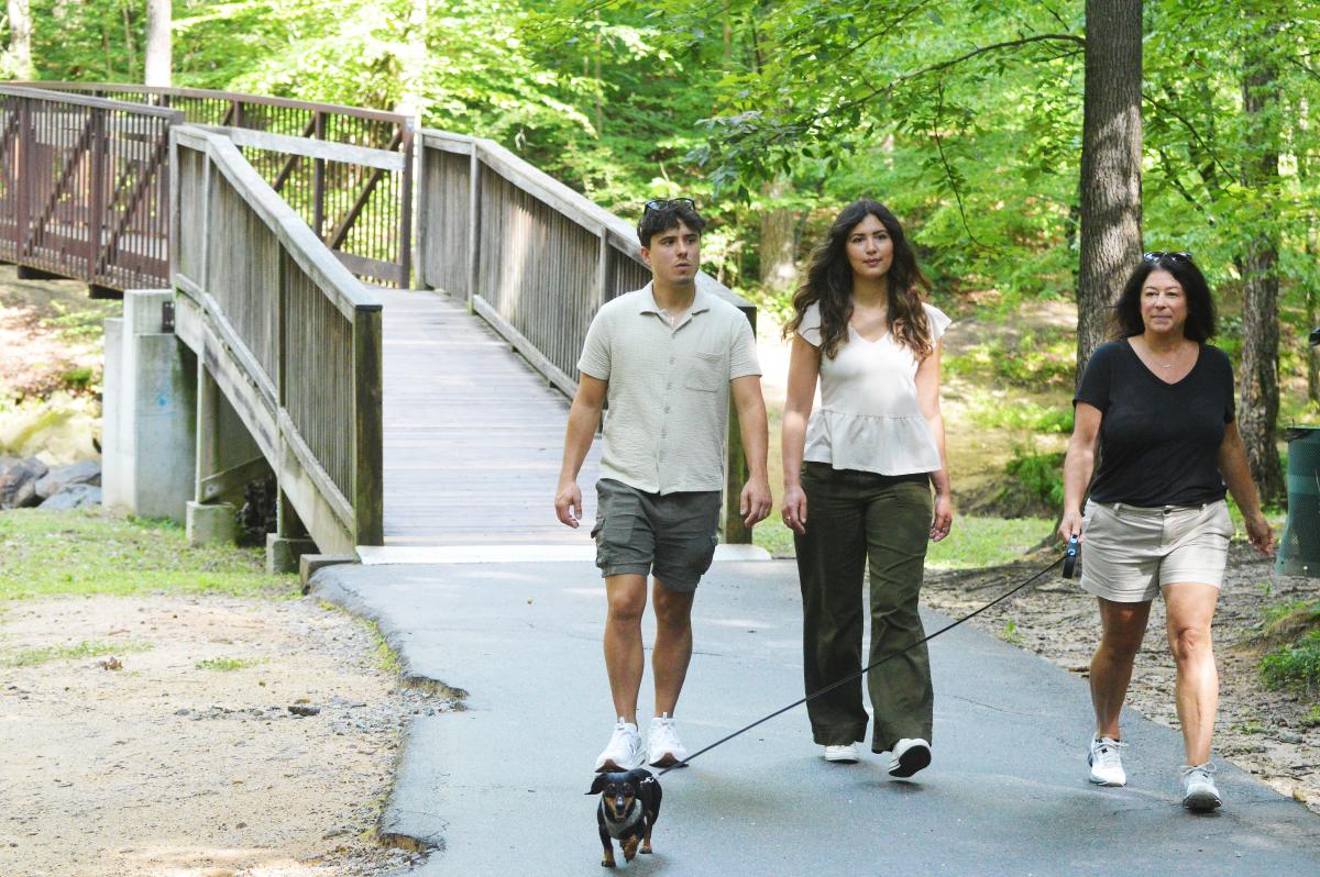 A family hiking with their dog in Creekside Park in Archdale, NC