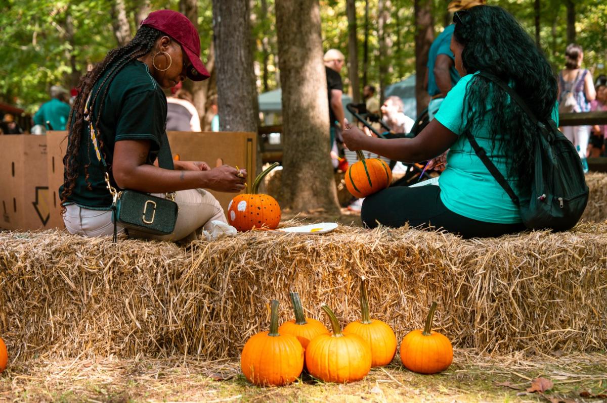 Two women painting pumpkins at Autumn Jubilee