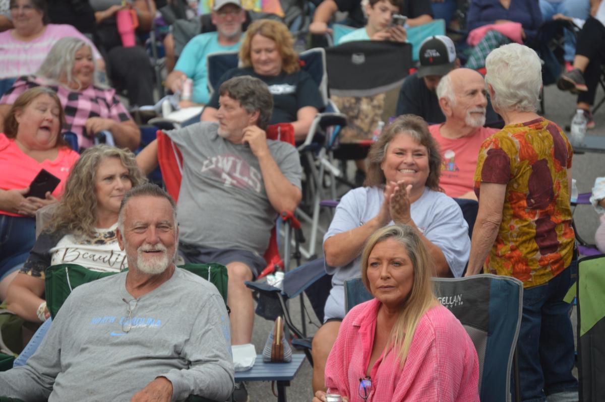 Crowd of people in lawn chairs enjoying live music