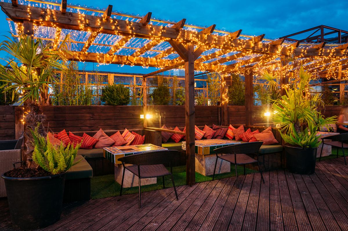 Funky Flamingo outdoor rooftop bar with pergola and large couches