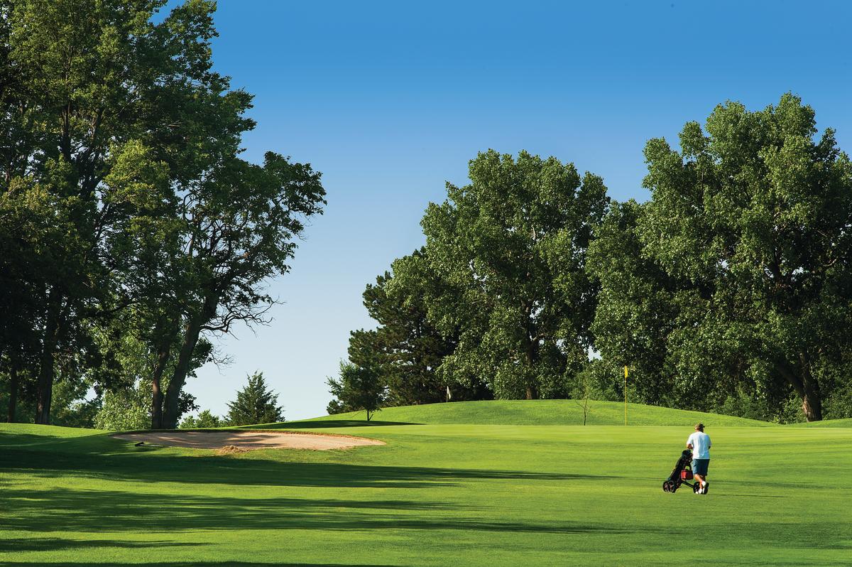 A man walks while golfing at Tex Consolver Golf course in Wichita