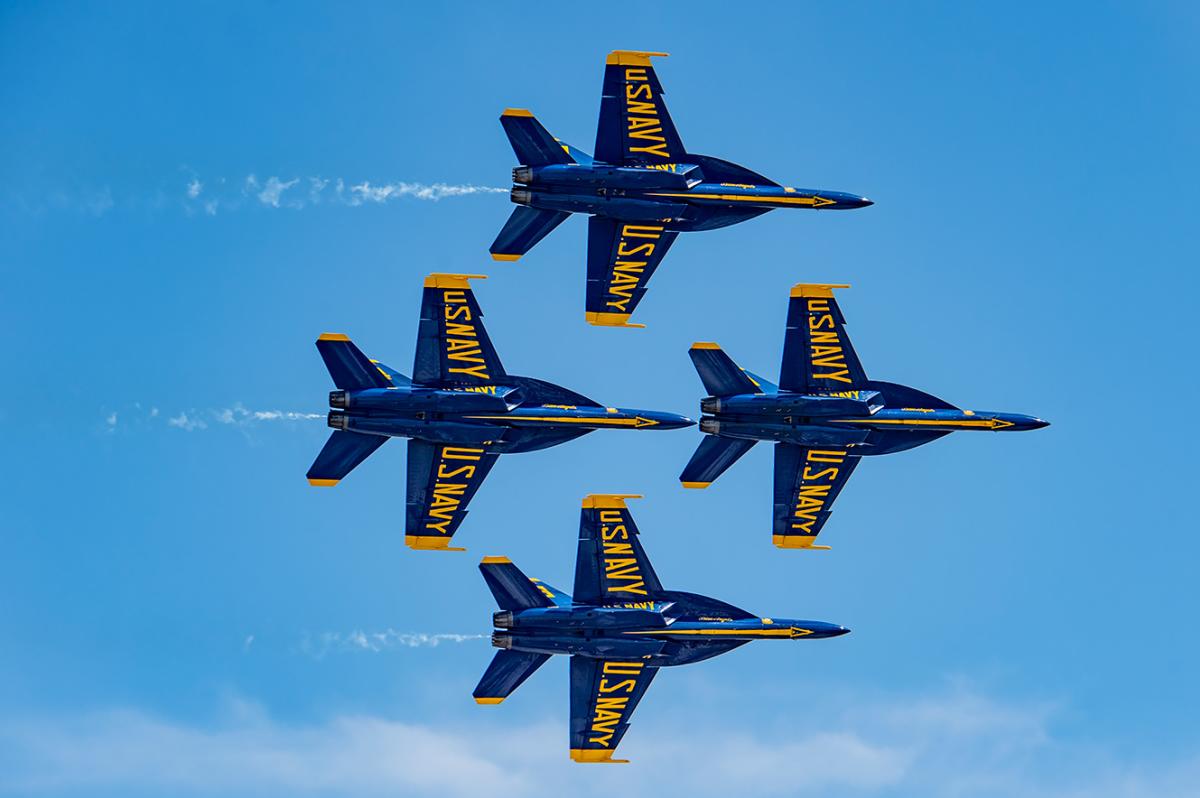 The United States Navy Blue Angels fly in the sky in their signature diamond pattern