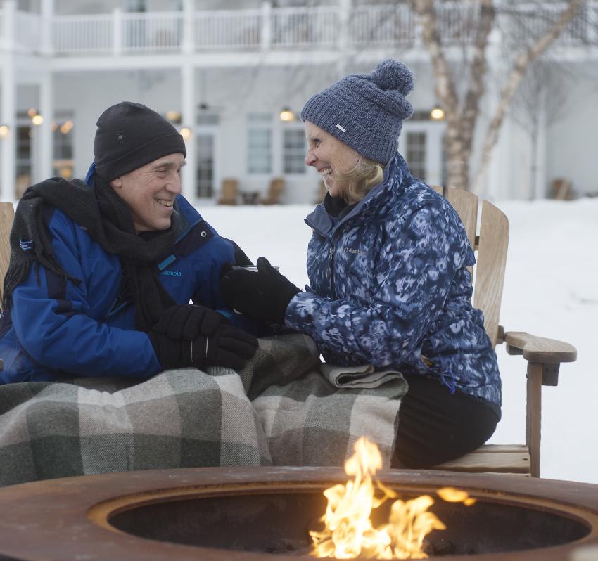 A couple enjoying the firepit by the water