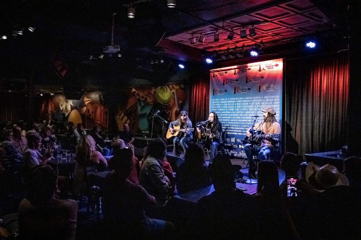 Three musicians on stage performing at Annapolis Songwriters Festival