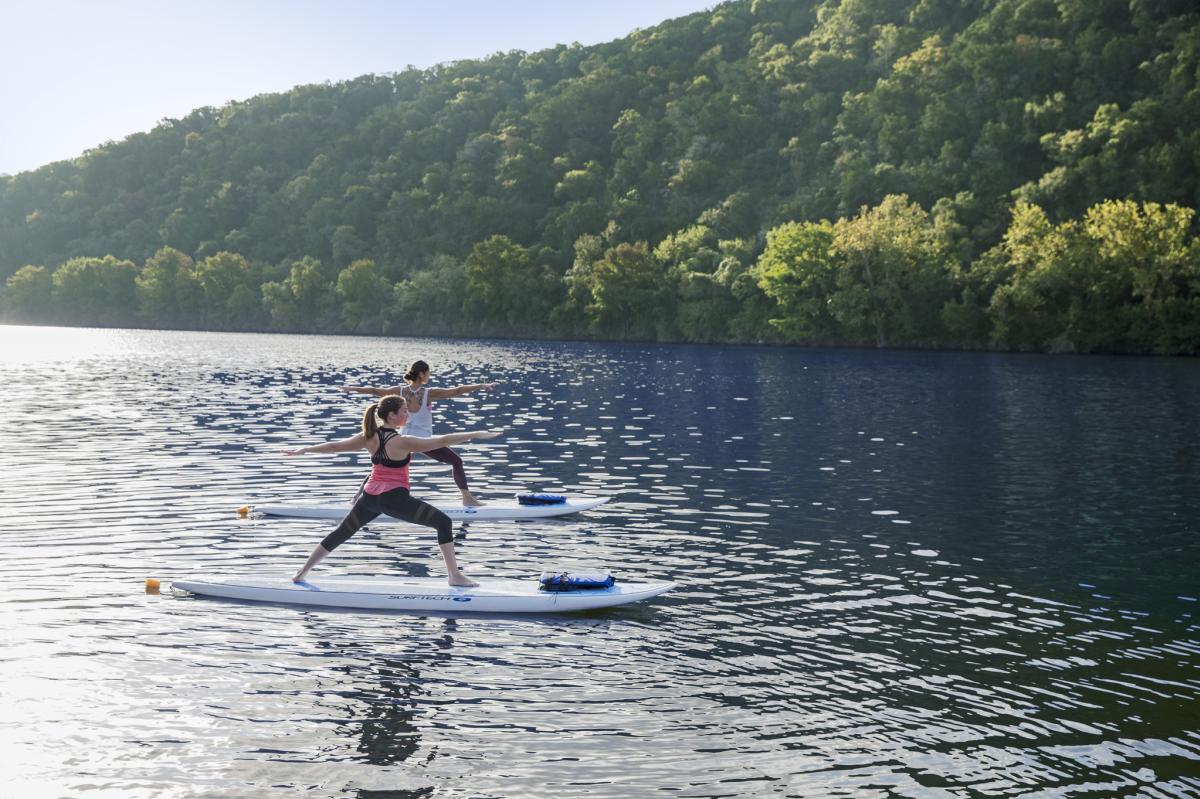 Image of two people doing paddleboard yoga at Lake Austin Spa Resort.
