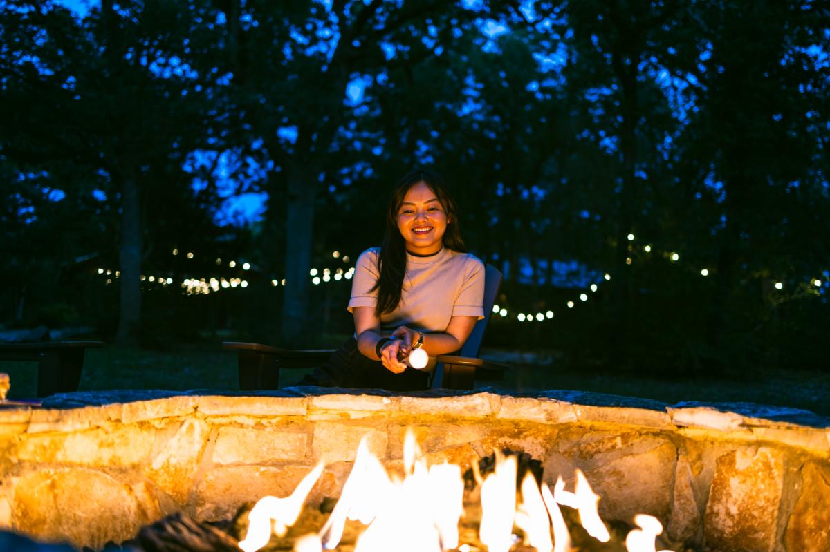 Influencer Rachel K. roasting marshmallow over campfire at the Reserve at Greenleaf.