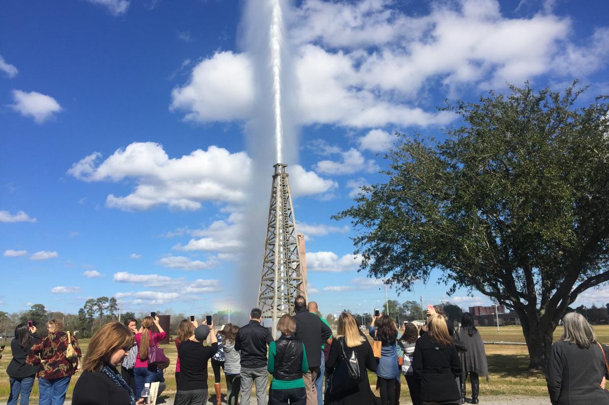 Visitors watch the Spindletop replica gusher blow