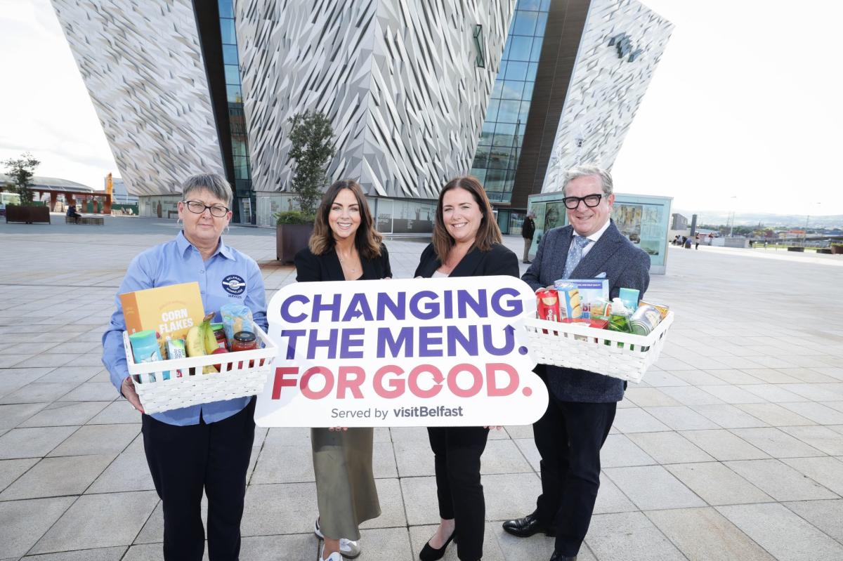 People standing outside Titanic Belfast holding food and a sign for changing the menu for good.