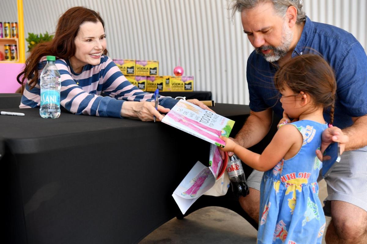 A little kid gets their book signed by Geena Davis