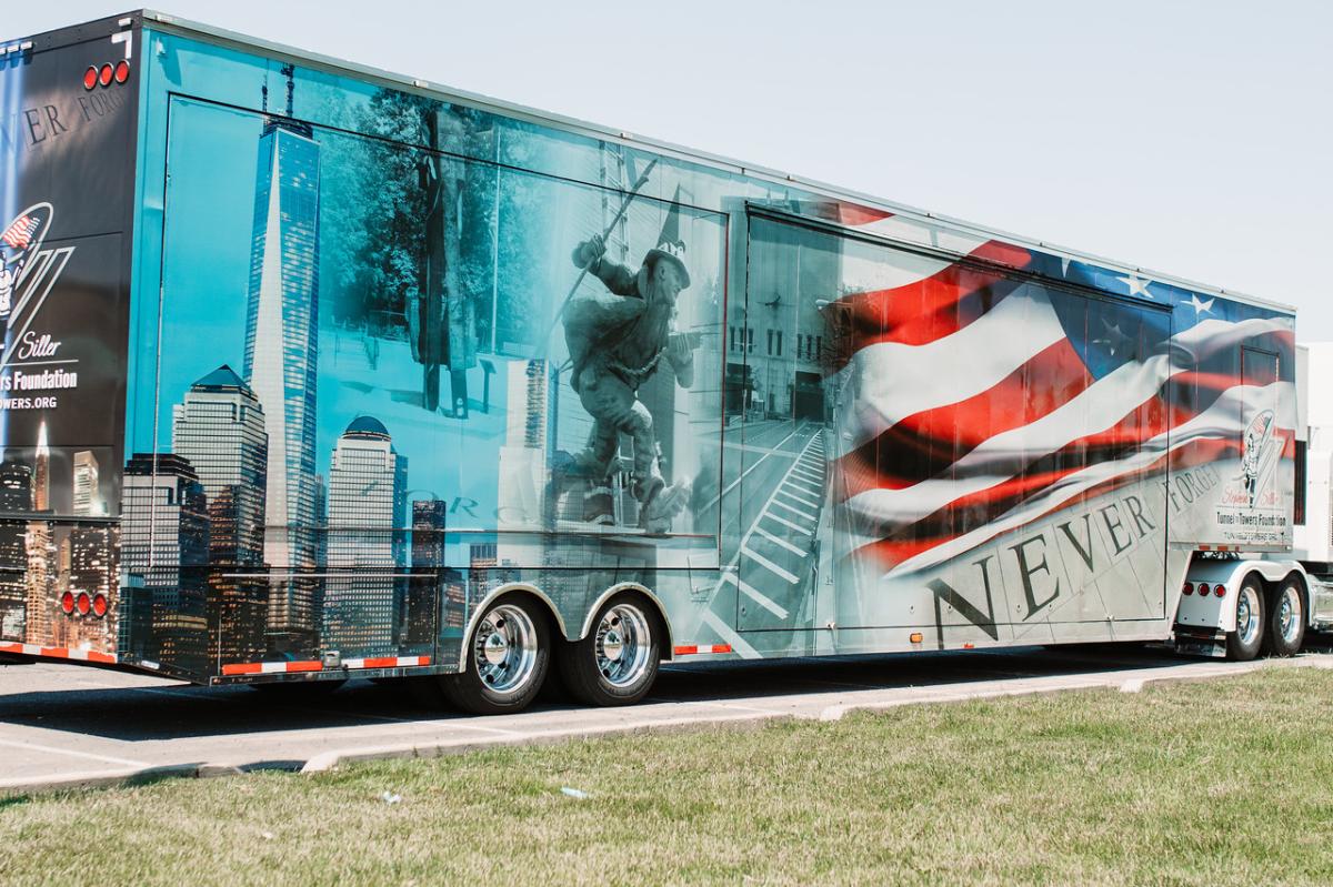 A truck carrying the 9/11 NEVER FORGET Mobile Exhibit features images of the Twin Towers, first responders and American flag