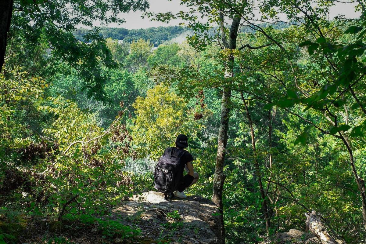 climber atop a bluff overlooking a river