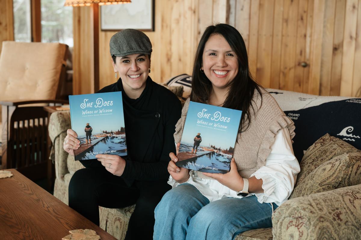 Two women holding the book they wrote