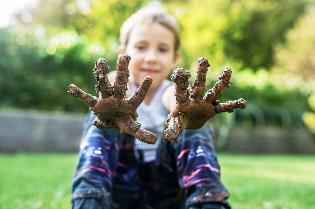 Little girl with muddy hands at WWT Slimbridge Mudfest